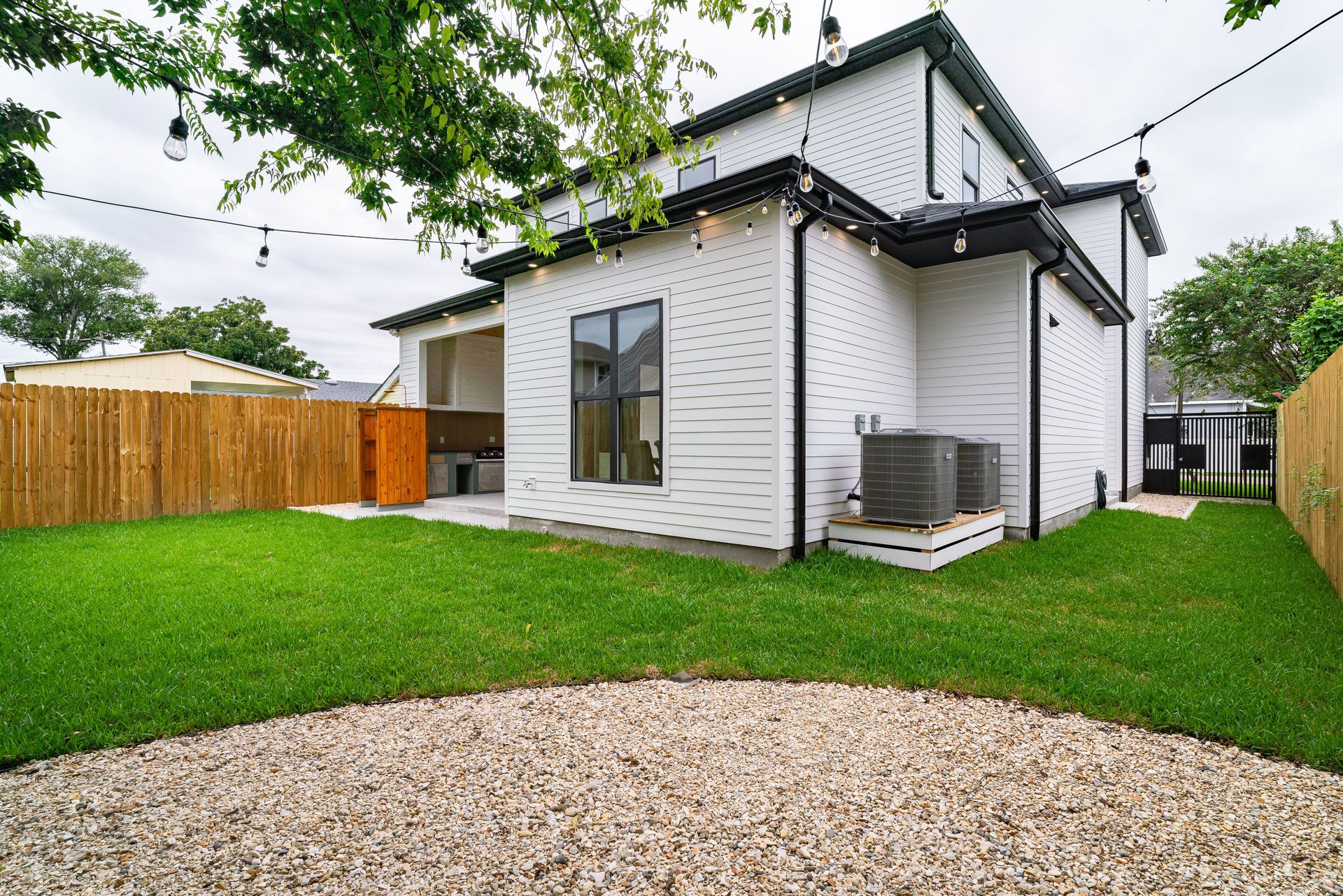 Spacious backyard view featuring a modern exterior and neat landscaping.