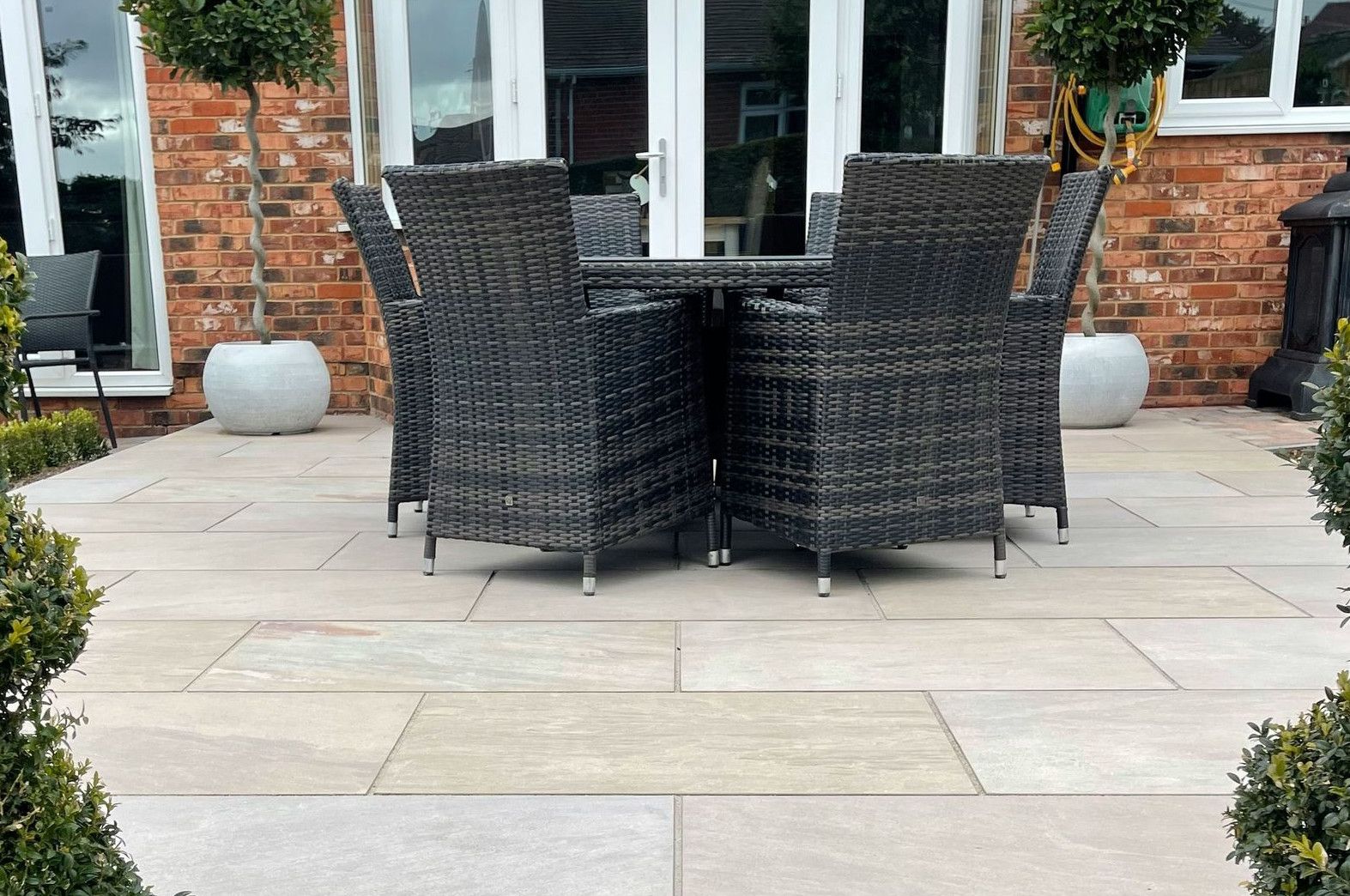 a patio with a table and chairs in front of a brick building
